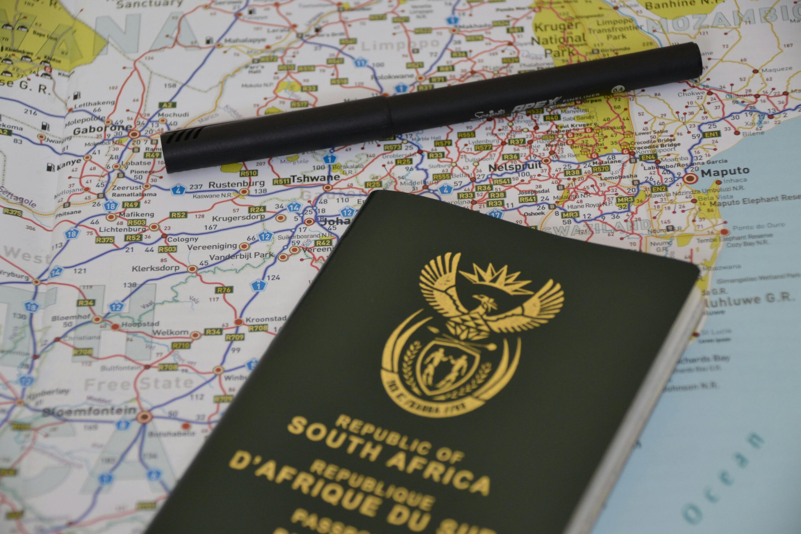 A South African passport rests on a detailed map, symbolizing travel and exploration.