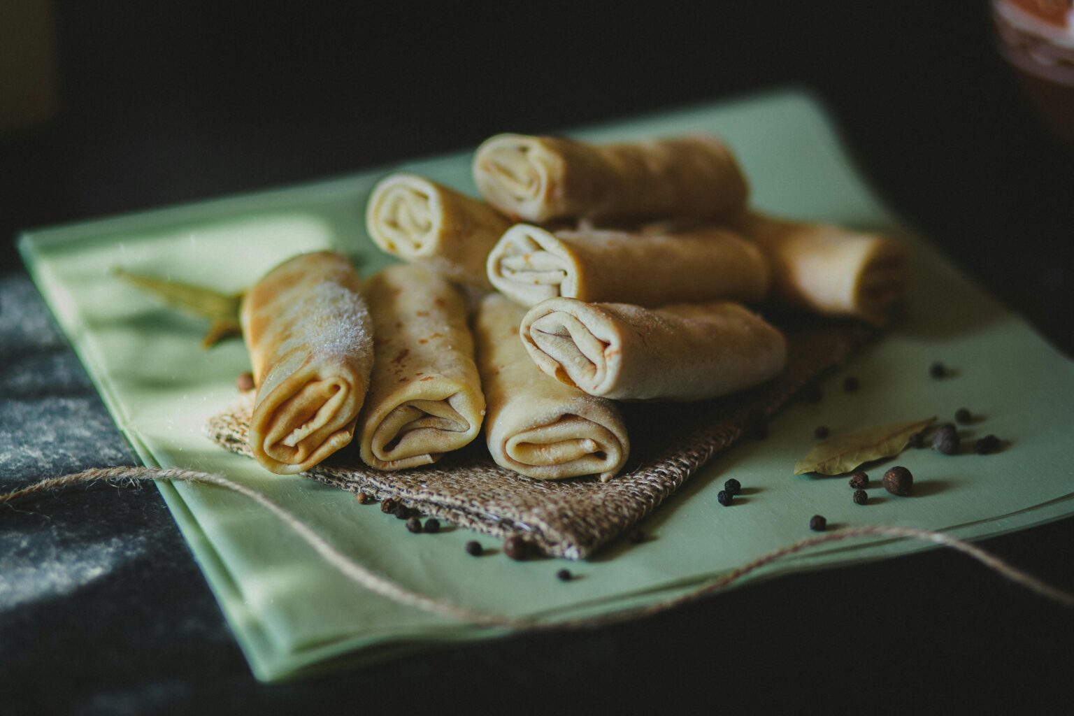 Delicious homemade crepes filled with spices, served on woven fabric, perfect for savory snacking.